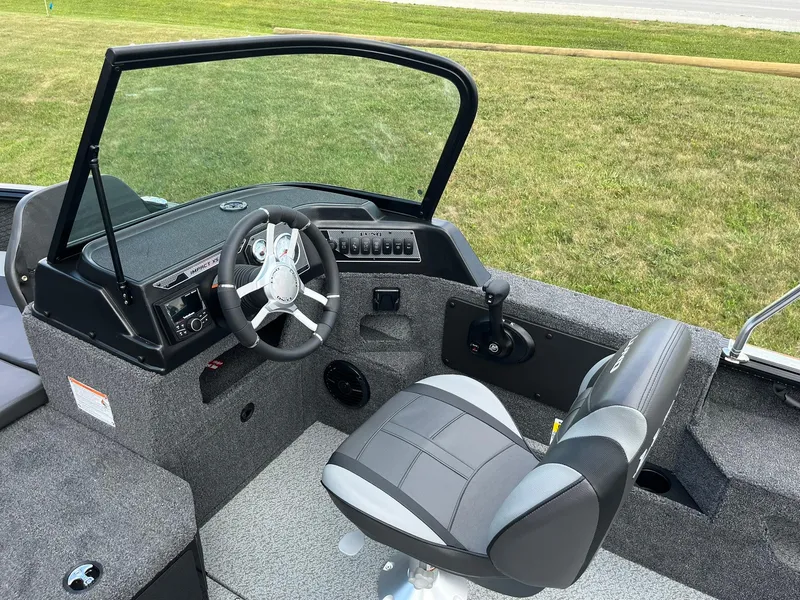 Slide: The Image of 2026 Lund 1775 Impact XS Sport boat interior with steering wheel and seat. - 15