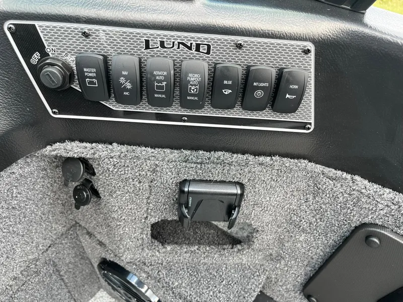 Slide: The Image of Control panel of 2026 Lund 1775 Impact XS Sport boat with various switches. - 17