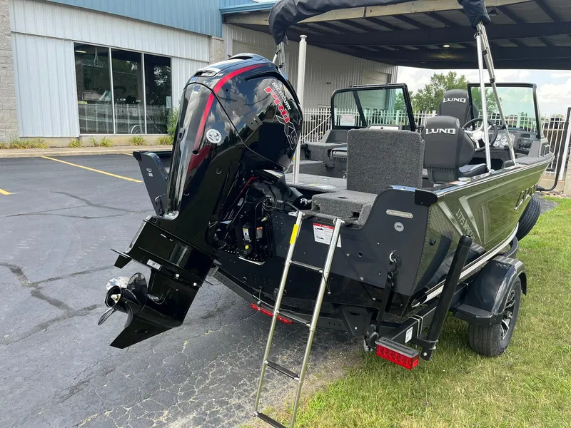 Slide: The Image of 2026 Lund 1775 Impact XS Sport boat with powerful outboard motor, parked outdoors. - 3