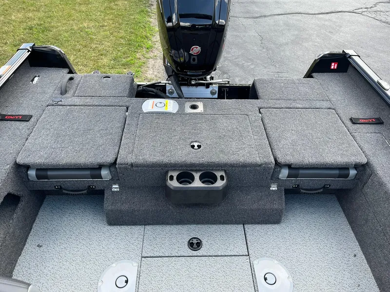 Slide: The Image of 2026 Lund 1775 Impact XS Sport boat interior with storage compartments and motor. - 9