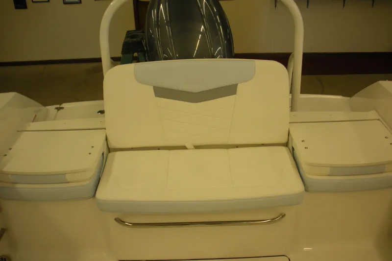 Slide: The Image of 2026 Robalo R207 Dual Console boat seating area with cushioned bench and storage compartments. - 19