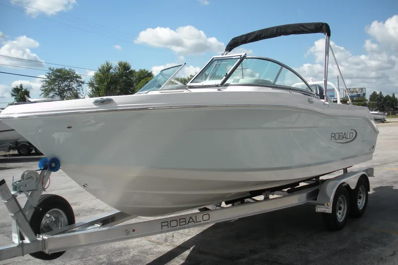 Slide: The Image of 2026 Robalo R207 Dual Console boat on trailer under clear sky. - 2