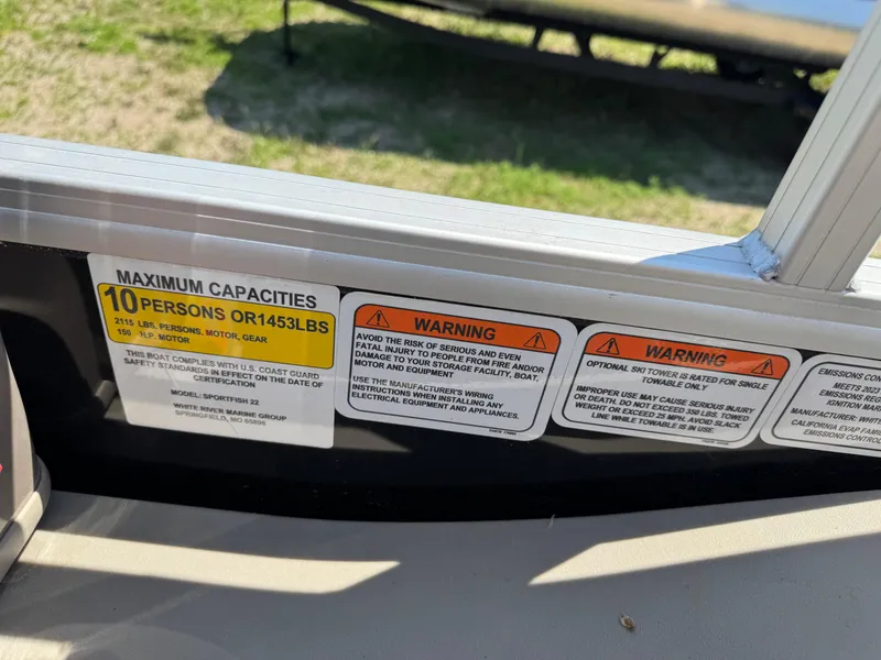 Slide: The Image of 2023 Sun Tracker SportFish 22 DLX capacity and warning labels on boat interior. - 14