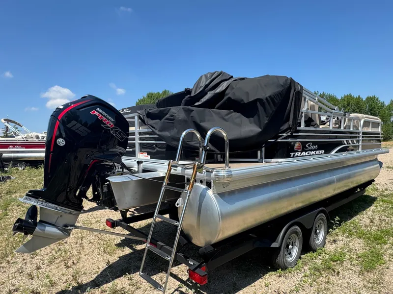 Slide: The Image of 2023 Sun Tracker SportFish 22 DLX pontoon boat with Mercury engine, parked on trailer. - 3