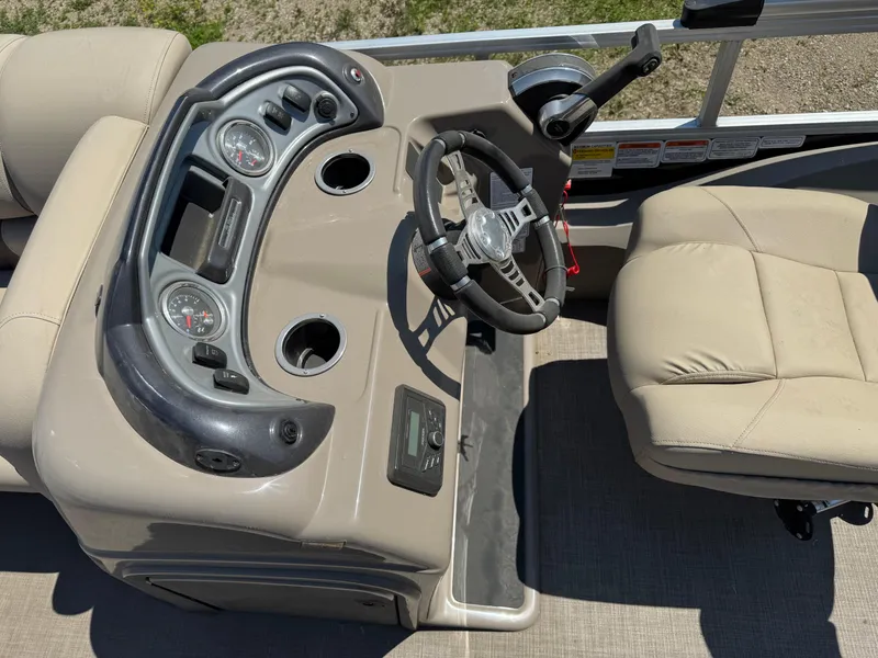 Slide: The Image of 2023 Sun Tracker SportFish 22 DLX boat dashboard with steering wheel and gauges. - 9