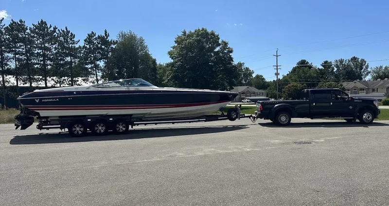 Slide: The Image of 2017 Formula 353 FASTech boat on trailer, towed by a black truck, outdoors. - 2