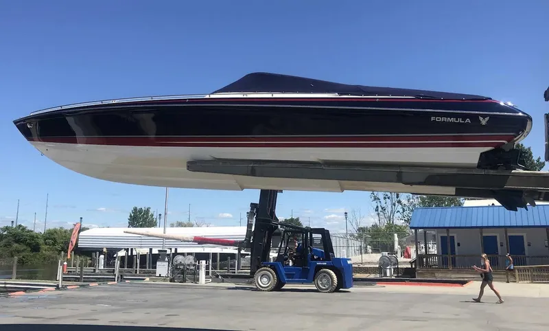 Slide: The Image of 2017 Formula 353 FASTech boat lifted by a forklift at a marina. - 8