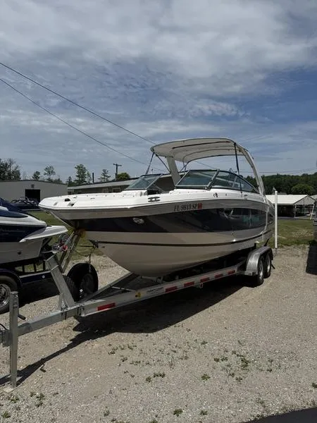 The Image of 2020 Regal 26 OBX boat on trailer, parked outdoors under cloudy sky. - 0