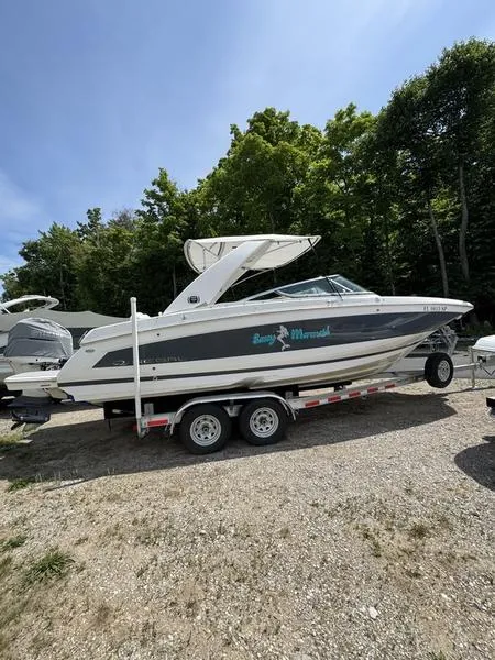Slide: The Image of 2020 Regal 26 OBX boat on trailer, parked outdoors with trees in the background. - 1