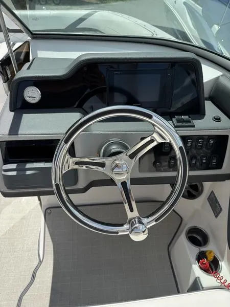 Slide: The Image of 2020 Regal 26 OBX boat dashboard with steering wheel and control panel. - 11