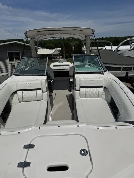 Slide: The Image of 2020 Regal 26 OBX boat with white seating and open deck under a clear sky. - 5