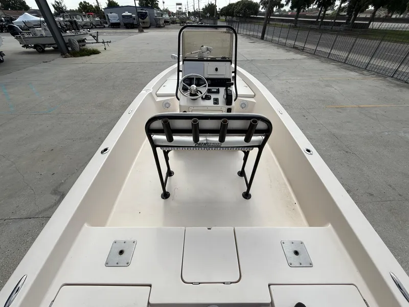 Slide: The Image of 2006 Pathfinder 2200v boat interior with steering console and rod holders, parked outdoors. - 8