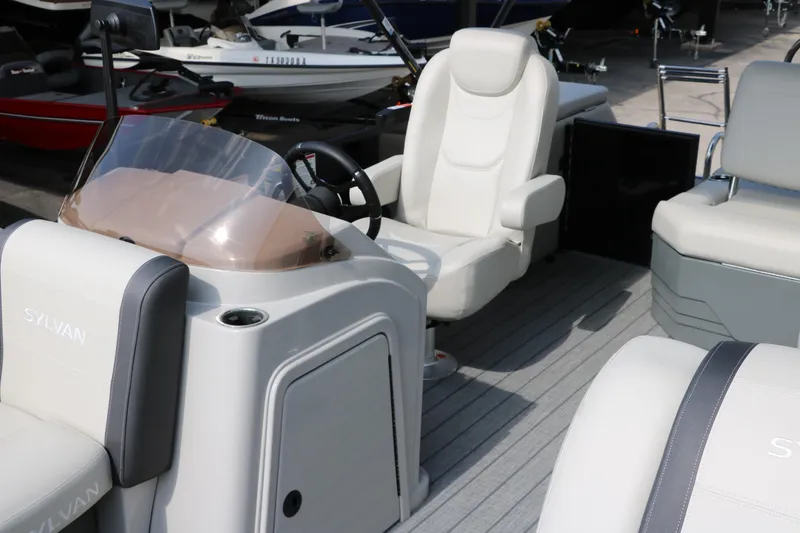 Slide: The Image of 2026 Sylvan Mirage Cruise 8520 CLZ DH interior with white seating and steering console. - 13