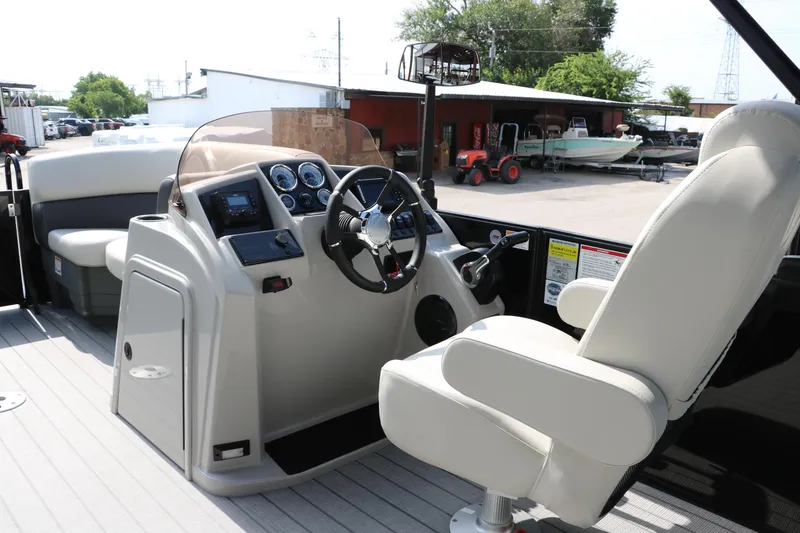 Slide: The Image of 2026 Sylvan Mirage Cruise 8520 CLZ DH boat interior with steering console and captain's chair. - 25