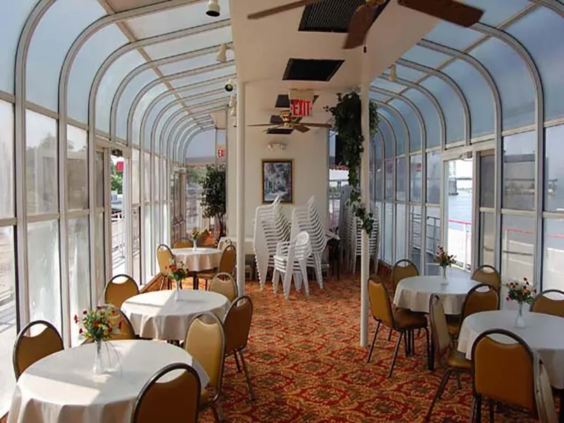 Slide: The Image of Elegant dining area on 1985 Custom Serodino Dinner Boat with round tables and floral decor. - 18