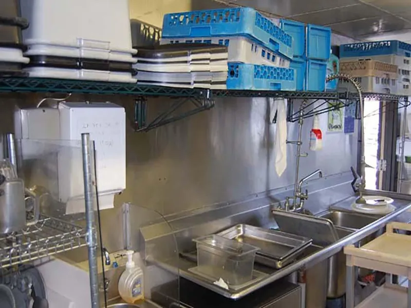 Slide: The Image of Kitchen area on 1985 Custom Serodino Dinner Boat with shelves, dishes, and sink. - 24