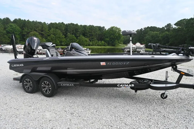 Slide: The Image of 2025 Caymas CX 19 boat on trailer, parked on gravel, with forested lake background. - 5