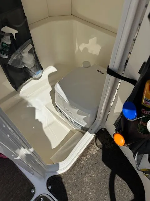 Slide: The Image of 2018 Sea Ray SPX 230 boat interior with portable toilet and storage compartments. - 11