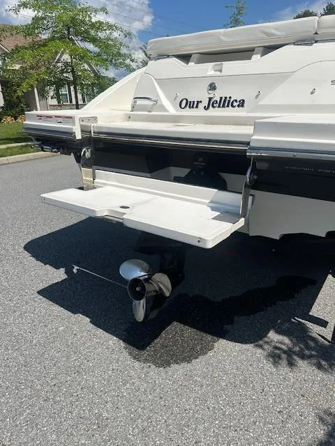 Slide: The Image of 2018 Sea Ray SPX 230 boat with swim platform and propeller, parked on a sunny street. - 3