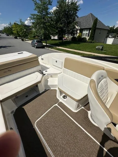 Slide: The Image of 2018 Sea Ray SPX 230 boat interior with beige seating and carpeted flooring. - 5