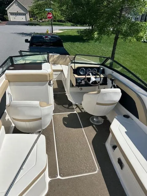 Slide: The Image of 2018 Sea Ray SPX 230 boat interior with beige seating and steering wheel. - 8
