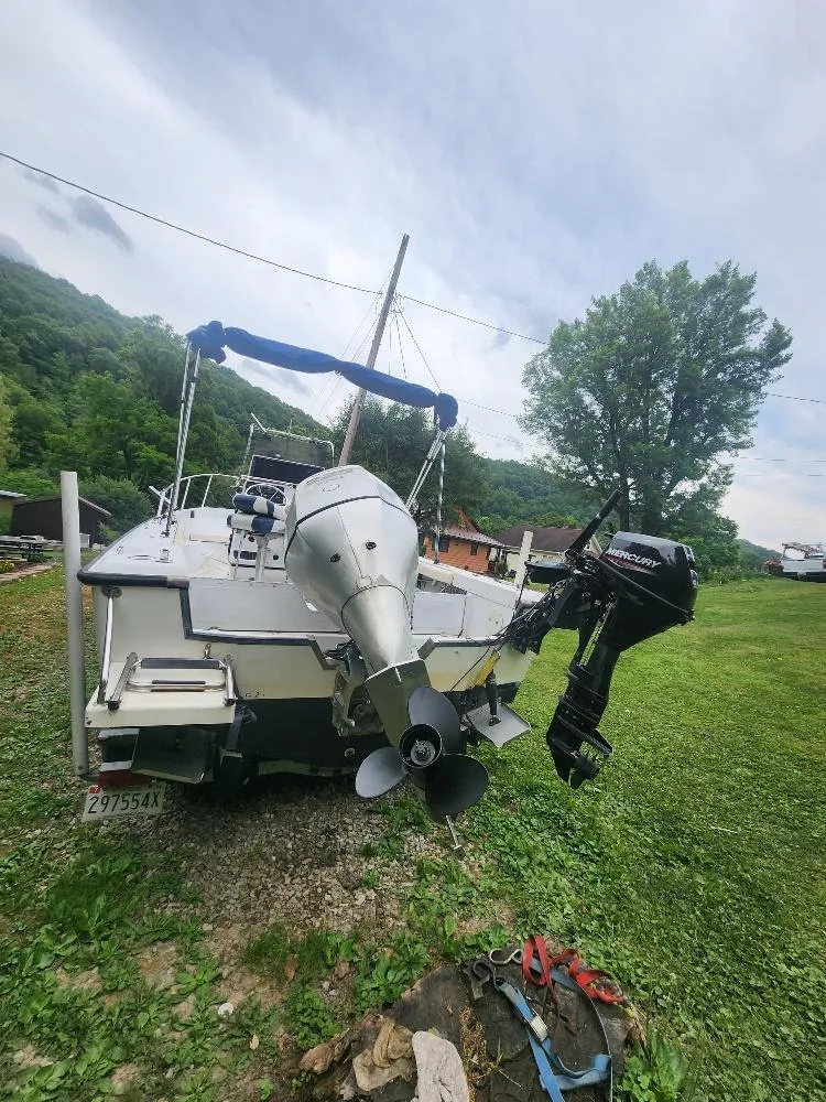 Slide: The Image of 1996 Boston Whaler 21 Outrage boat with Mercury outboard motor on grassy area. - 3