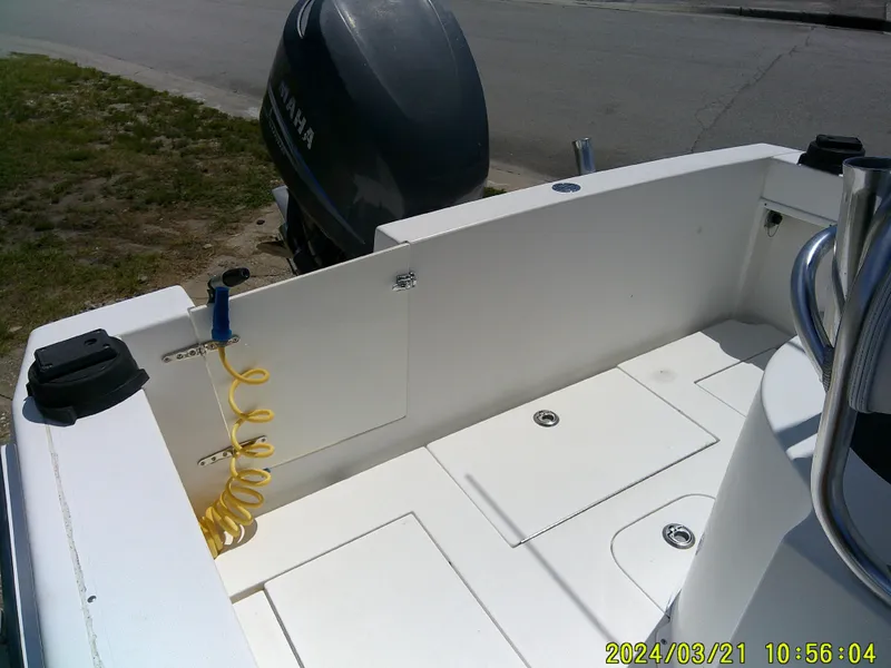 Slide: The Image of 2004 Contender 23 Open boat interior with Yamaha engine, featuring clean deck and coiled hose. - 13