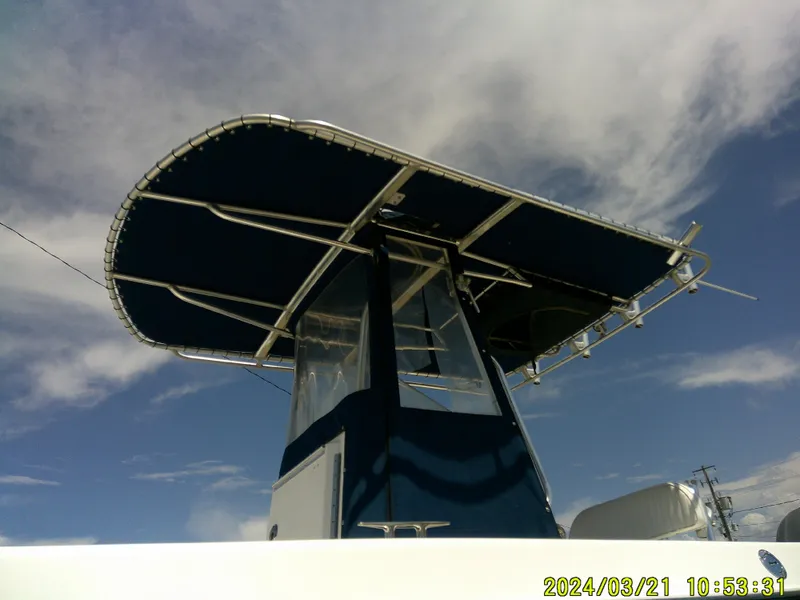 Slide: The Image of 2004 Contender 23 Open boat with T-top against a blue sky. - 14