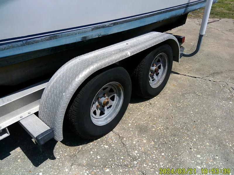 Slide: The Image of Trailer wheels of a 2004 Contender 23 Open boat on concrete surface. - 15