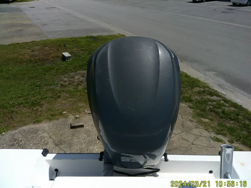 Slide: The Image of Outboard motor on a 2004 Contender 23 Open boat, parked on a roadside. - 17