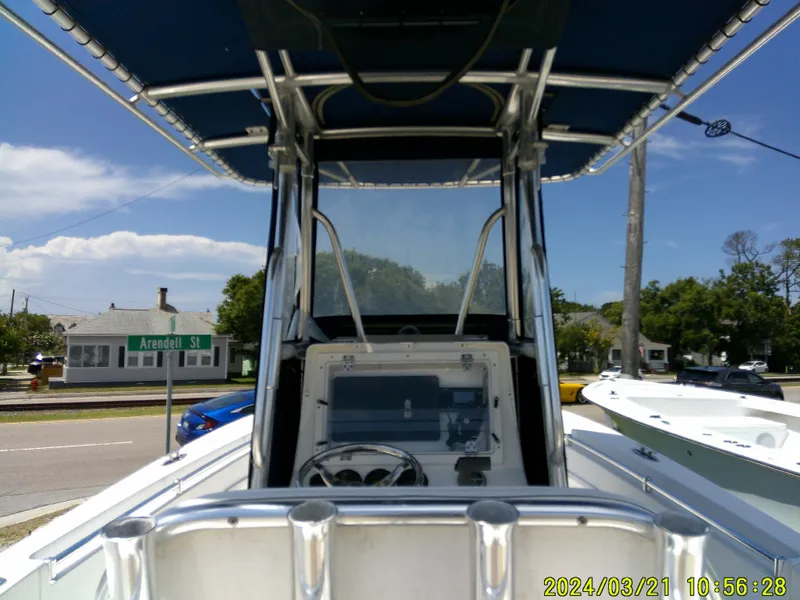 Slide: The Image of 2004 Contender 23 Open boat with T-top, parked near Arendell Street, under clear blue sky. - 21