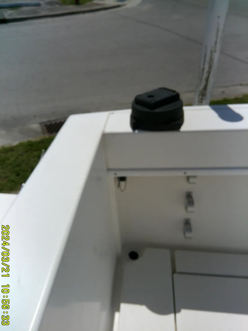 Slide: The Image of 2004 Contender 23 Open boat interior with storage compartment and black cap. - 24