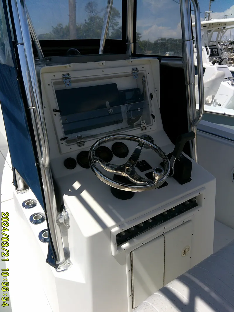 Slide: The Image of 2004 Contender 23 Open boat console with steering wheel and controls. - 26