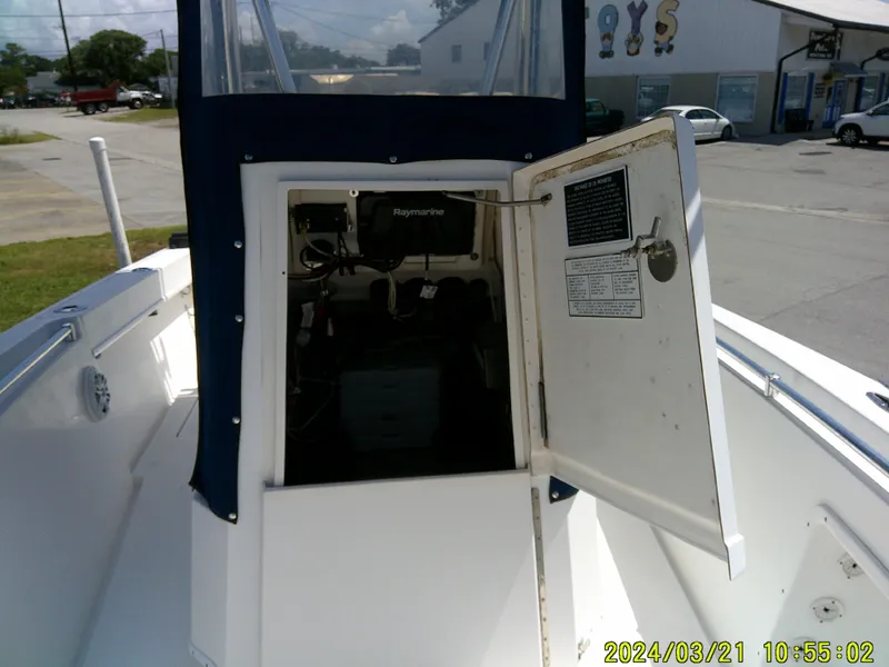 Slide: The Image of 2004 Contender 23 Open boat interior with open storage compartment and visible Raymarine equipment. - 27