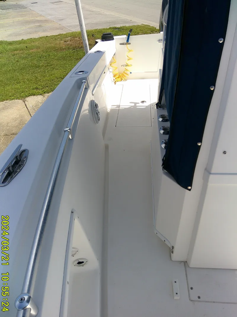 Slide: The Image of 2004 Contender 23 Open boat deck with railing and hose, parked on pavement. - 4