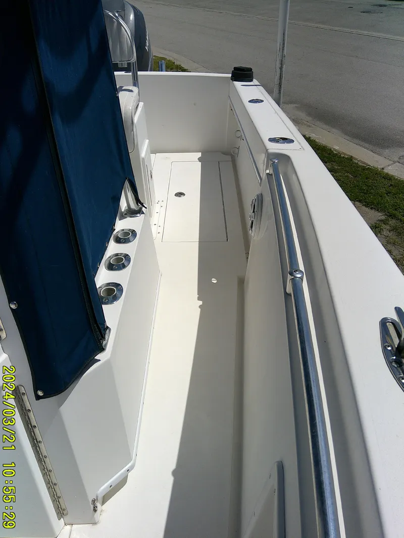 Slide: The Image of 2004 Contender 23 Open boat interior with rod holders and blue canvas cover. - 7