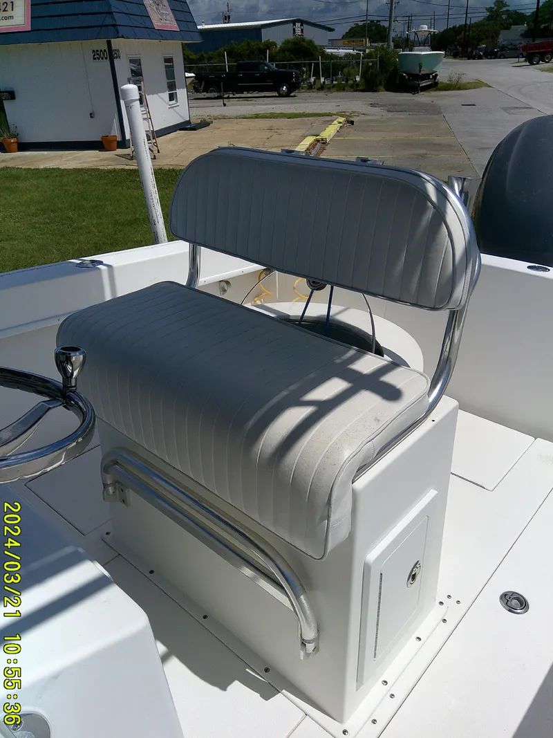 Slide: The Image of 2004 Contender 23 Open boat seat with white upholstery and chrome accents. - 9