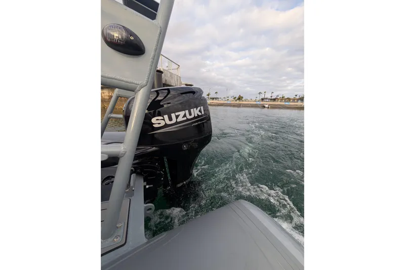 Slide: The Image of 2026 Tide Craft Custom Catalina 13 with Suzuki motor on water, grey and orange design. - 7