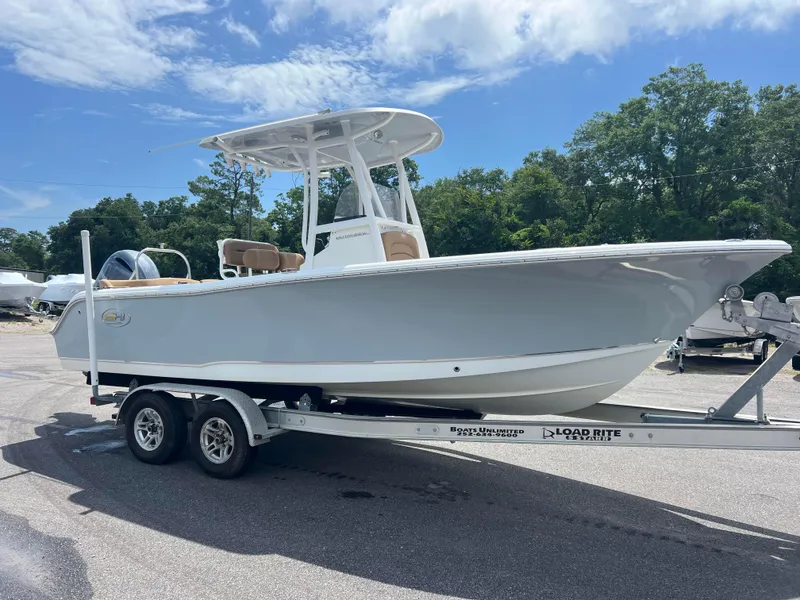 Slide: The Image of 2022 Sea Hunt Ultra 229 boat on trailer, parked outdoors under a clear blue sky. - 4