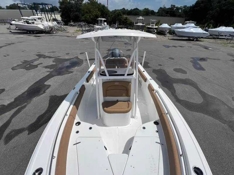 Slide: The Image of 2022 Sea Hunt Ultra 229 boat with tan seating, parked in a marina. - 8