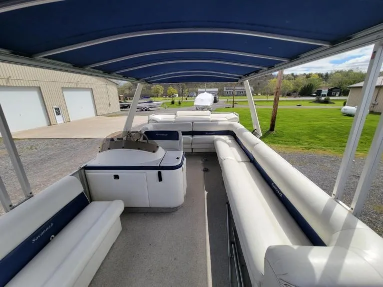 Slide: The Image of Interior view of a 1999 Crest 30 Savannah pontoon boat with blue canopy and white seating. - 2
