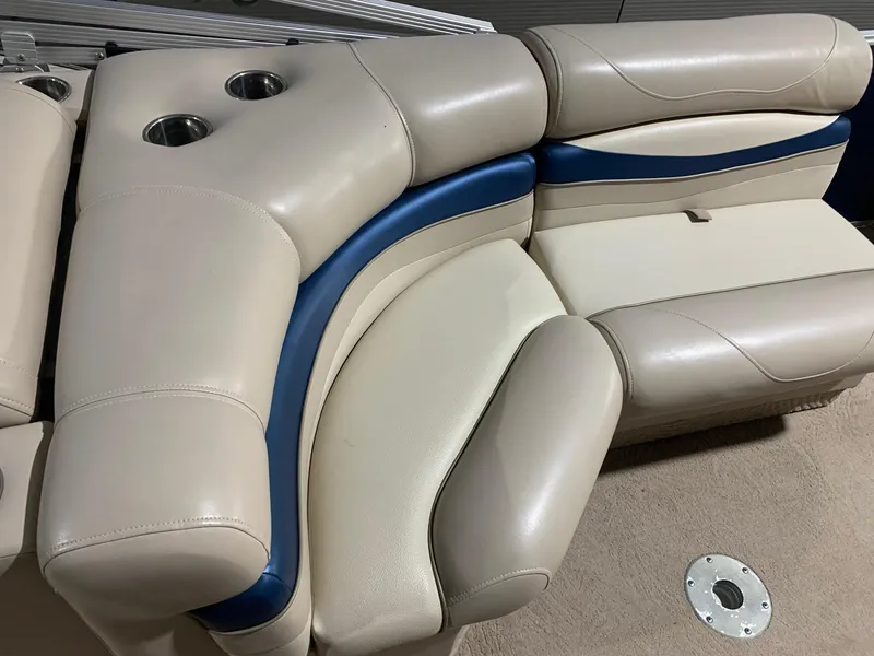 Slide: The Image of 2010 Bennington 2250RCW boat seating with beige and blue upholstery, featuring cup holders. - 11