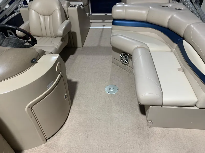 Slide: The Image of Interior of a 2010 Bennington 2250RCW pontoon boat with beige seating and steering console. - 14