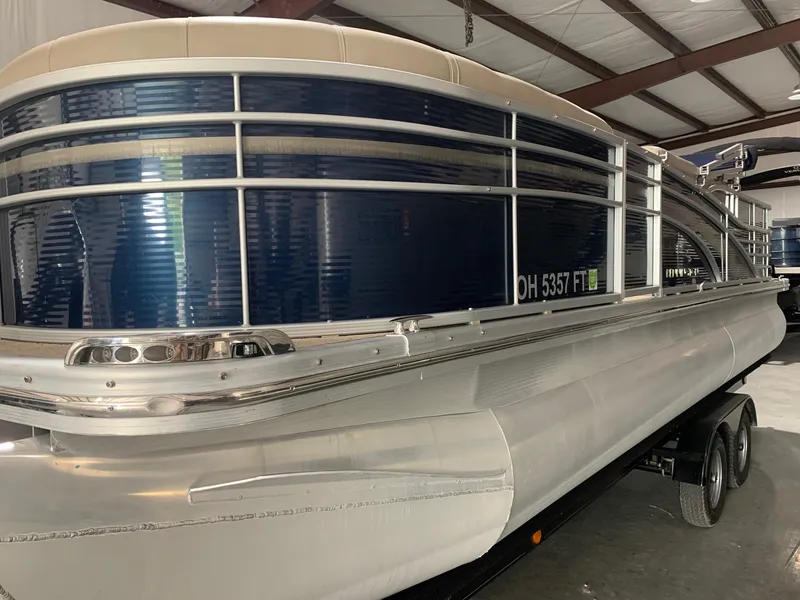 Slide: The Image of 2010 Bennington 2250RCW pontoon boat in a warehouse, side view. - 2