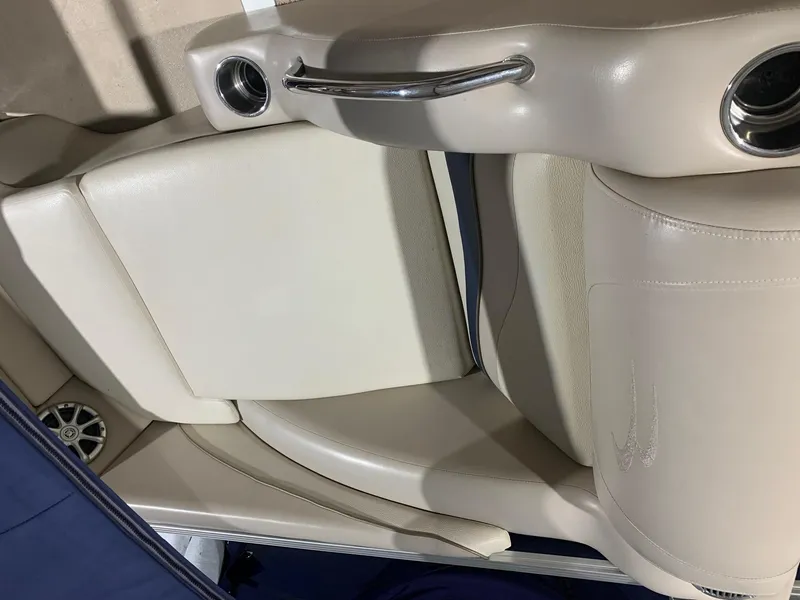 Slide: The Image of Interior of a 2010 Bennington 2250RCW boat with beige seating and cup holders. - 26