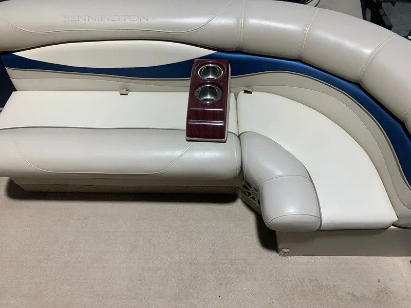 Slide: The Image of Bennington 2250RCW 2010 boat seating with cup holders, featuring beige and blue upholstery. - 9