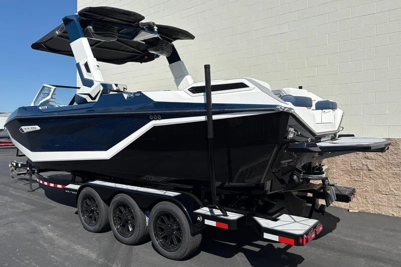 Slide: The Image of 2026 Nautique Super Air Nautique G25 Paragon boat on trailer, sleek design, black and white finish. - 2
