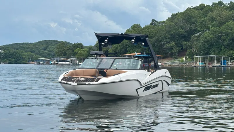 Slide: The Image of 2025 MB B52 23 Alpha boat on a serene lake with lush green surroundings. - 4