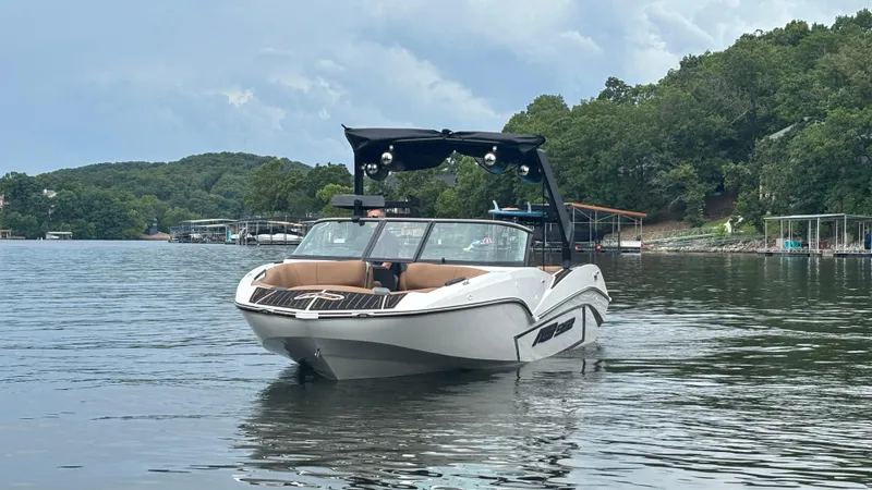 Slide: The Image of 2025 MB B52 23 Alpha boat on a serene lake with lush green surroundings. - 5