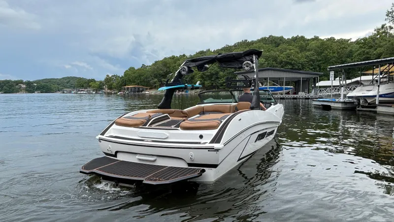 Slide: The Image of 2025 MB B52 23 Alpha boat on a serene lake with lush green surroundings. - 7